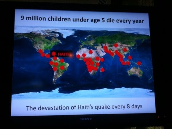 Esther Duflo uses her slides to show the devastation of Haiti's quake every 8 days by giving them a human context