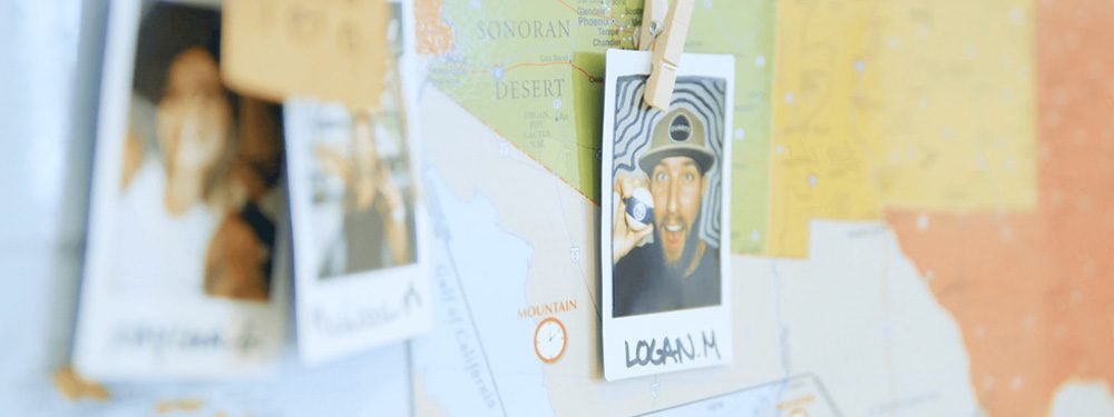 A close-up of a map with an Instax image of "Logan M" held by a clothespin.