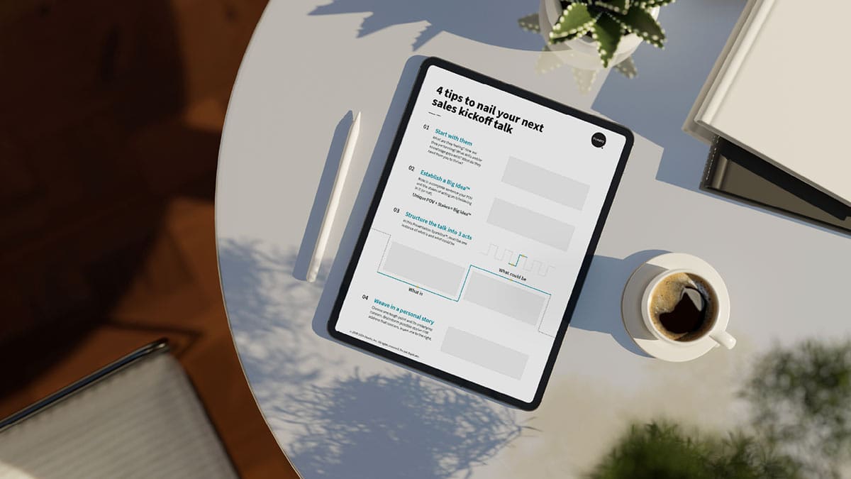 A table with a coffee cup, plant, and tablet on it. The tablet shows "4 tips to nail your next sales kickoff talk."